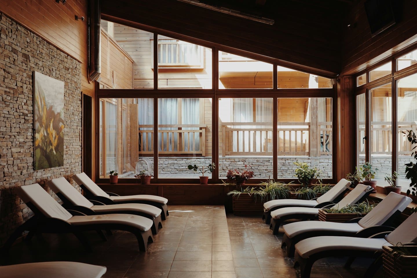 Sillones en una zona de relax con detalles de piedra y madera.