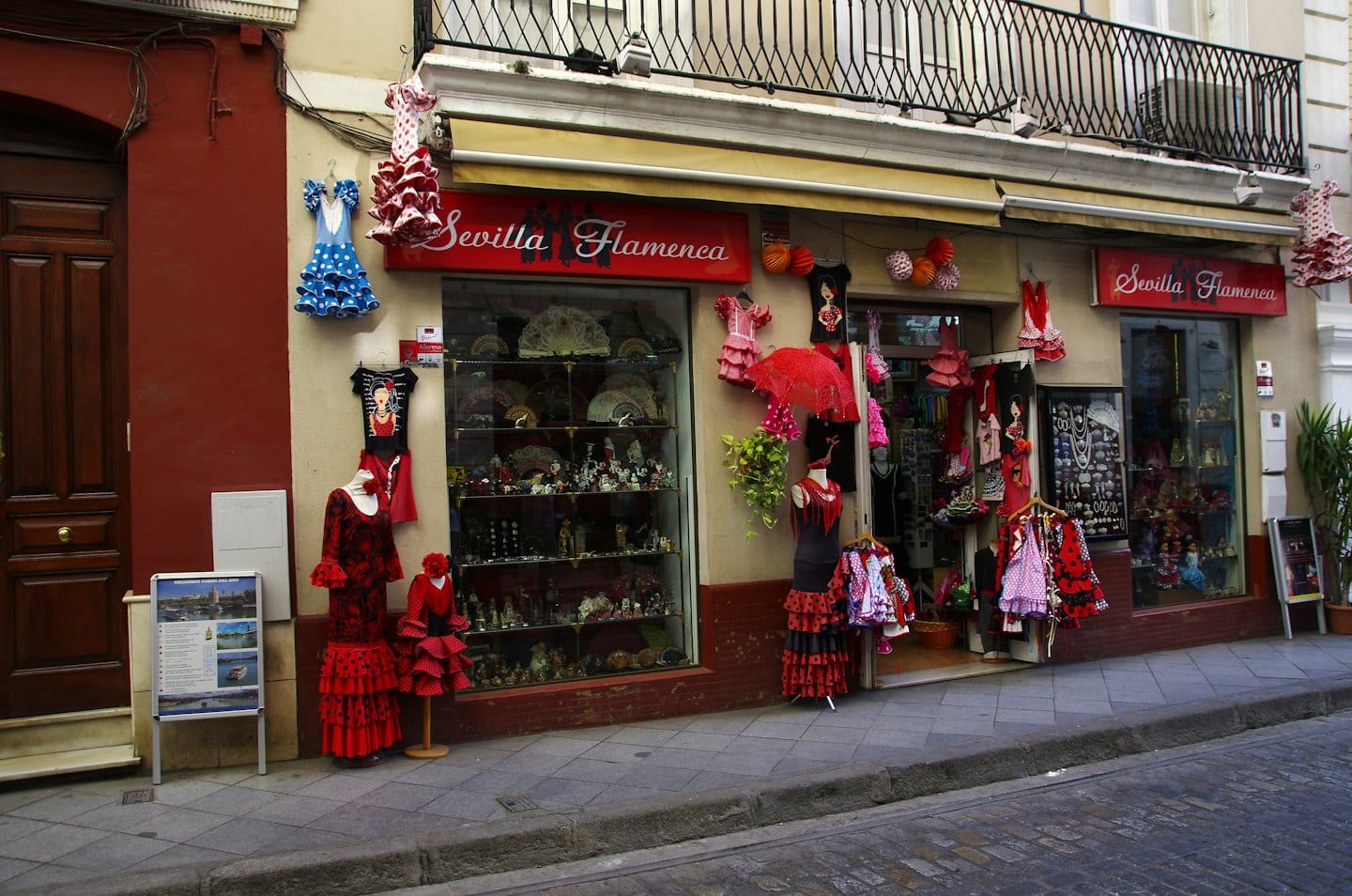 Maniquíes con vestidos flamencos rojos están afuera de una tienda de recuerdos.